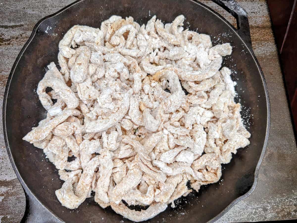 Mongolian soy curls coated with cornstarch in pan.