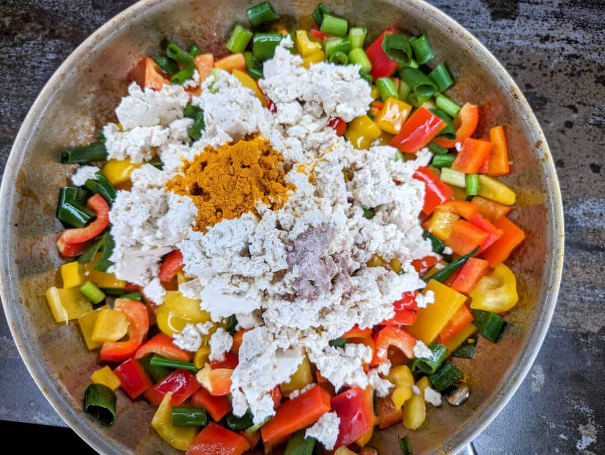 Tofu scramble in pan with shredded tofu, turmeric, and black salt.