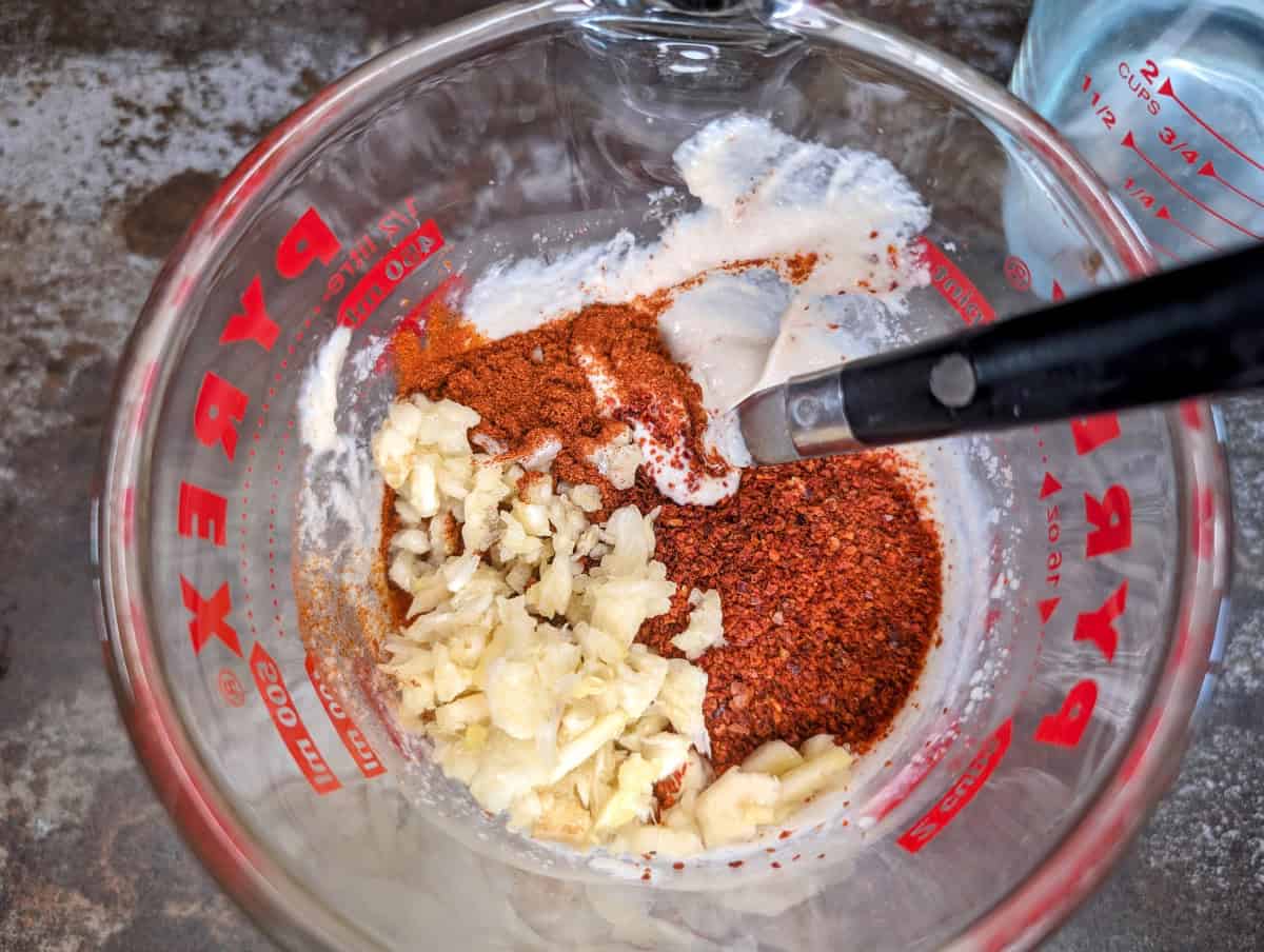 Add the spices and garlic to the tahini and lemon juice mixture.