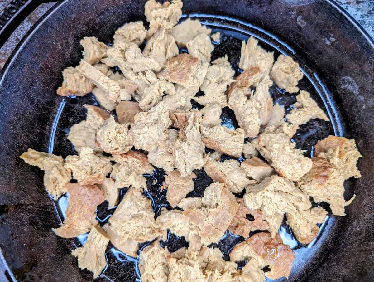 Once the oil is shimmering, place the shredded seitan in the pan.