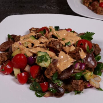 the bean, bread, tomato salad plated with tahini dressing