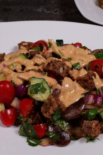 the bean, bread, tomato salad plated with tahini dressing