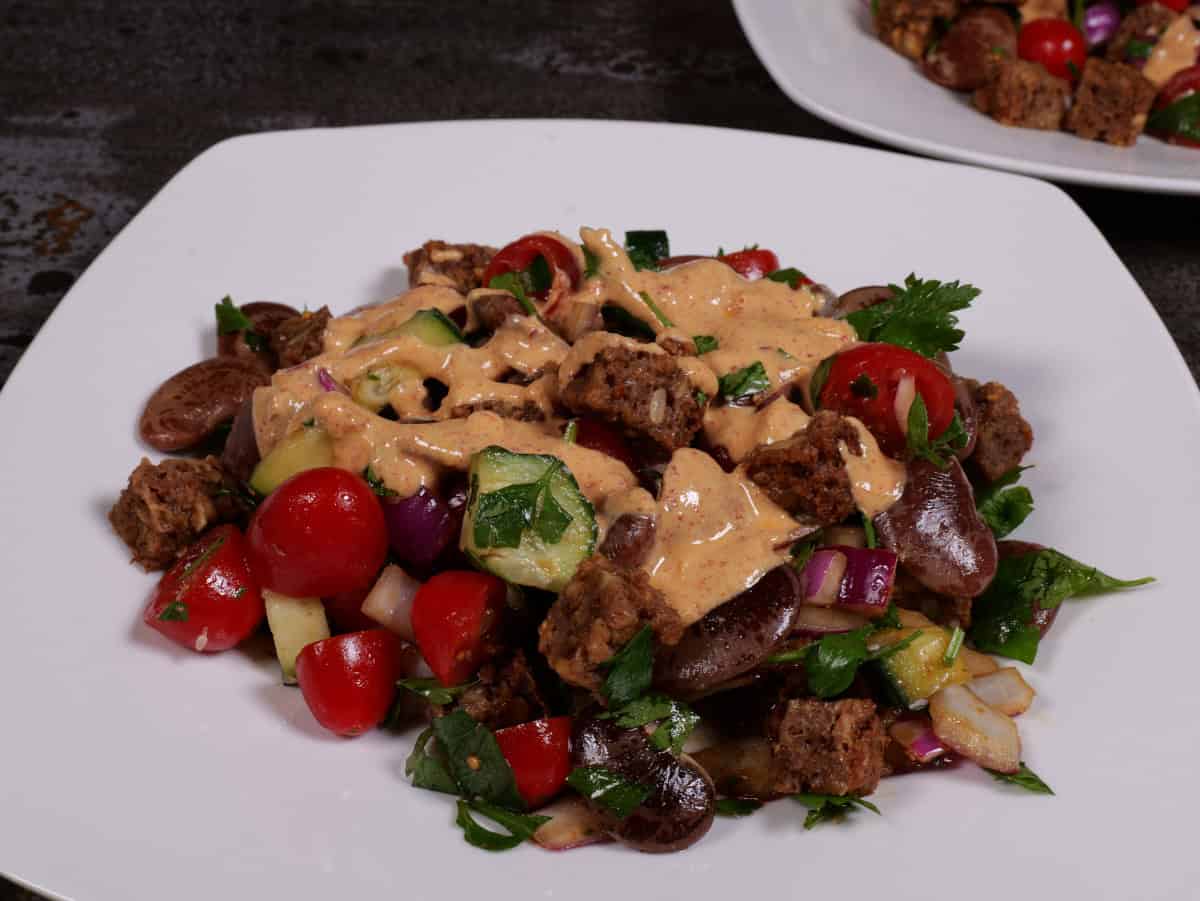 the bean, bread, tomato salad plated with tahini dressing