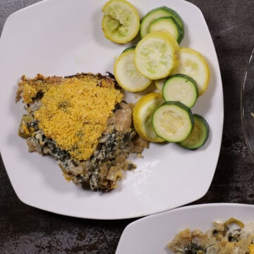 cheese, leek, and artichoke pie plated with green and yellow summer squash
