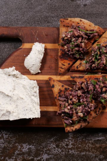 Olive/walnut tapenade with plant-based cheese on board.