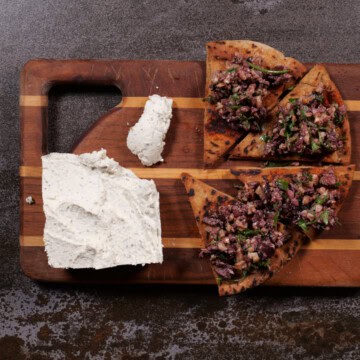 Olive/walnut tapenade with plant-based cheese on board.