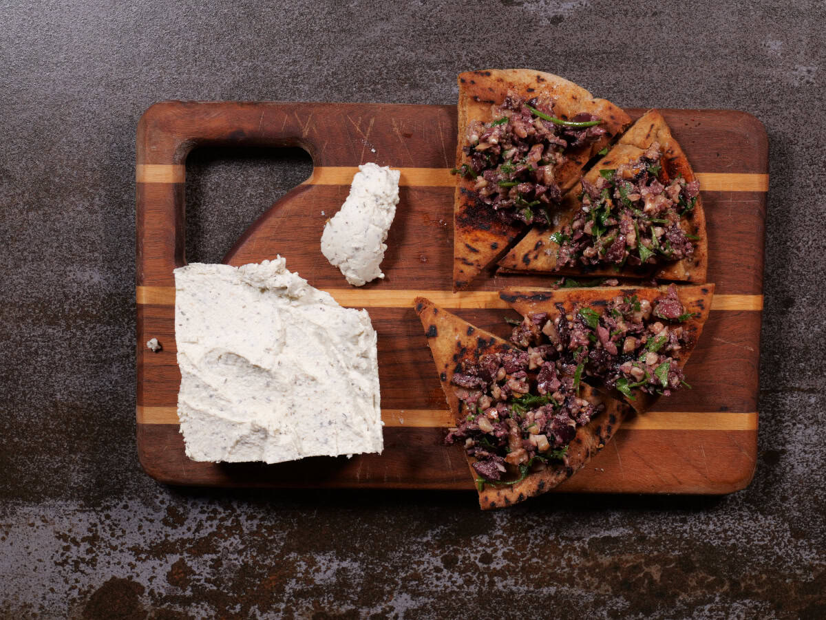 Olive/walnut tapenade with plant-based cheese on board.