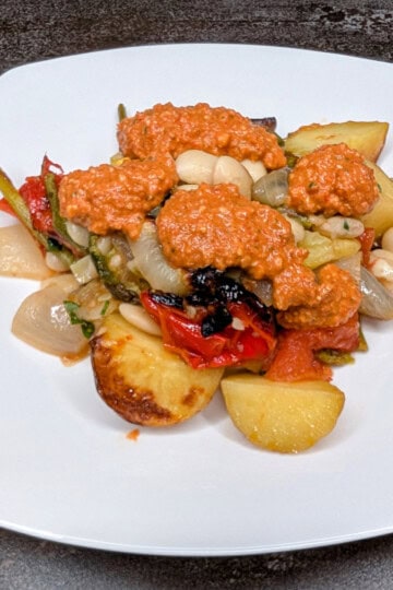 Romesco sauce over onions and butter beans