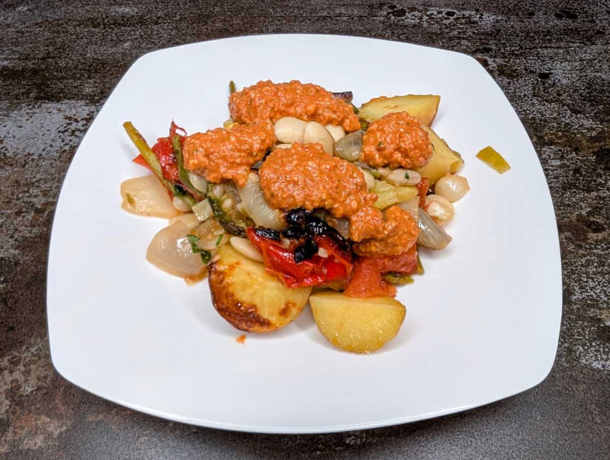Romesco sauce over onions and butter beans