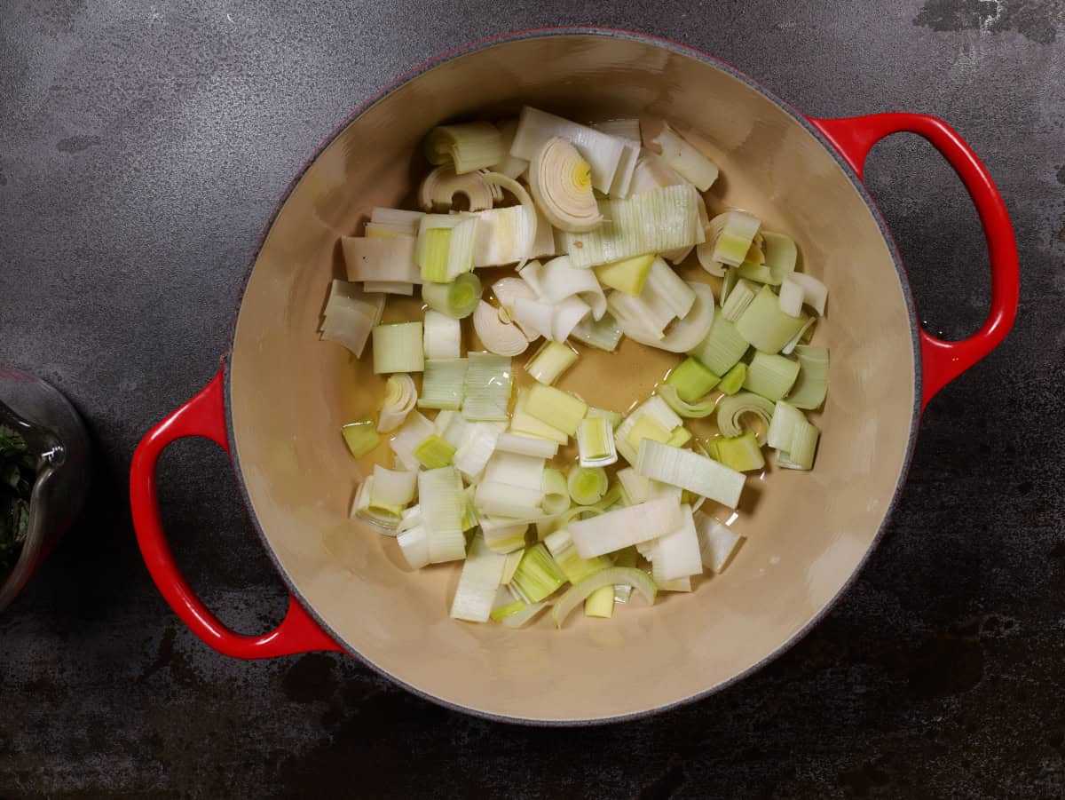raw leeks added to pot in hot oil