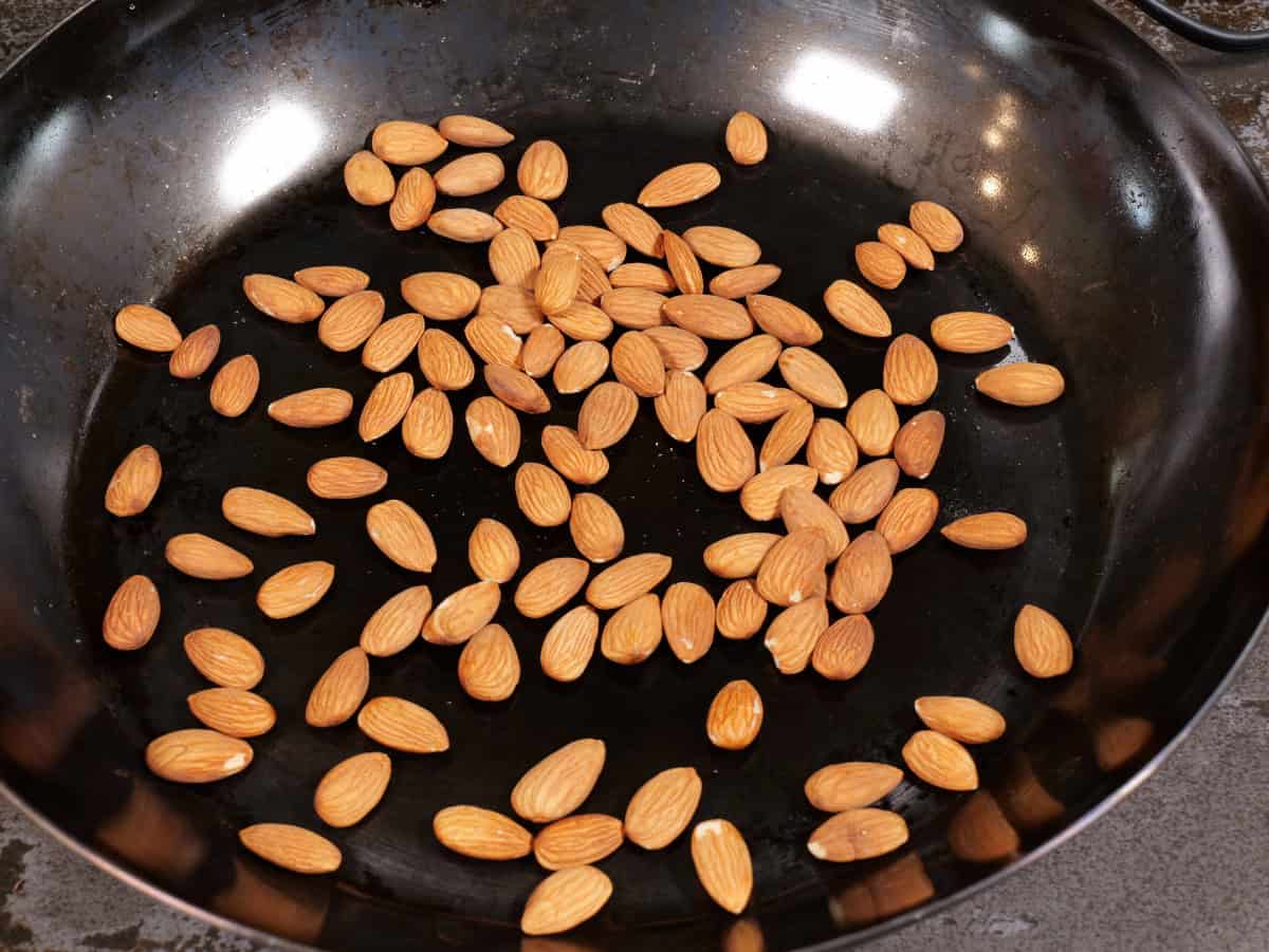Romesco sauce, step 1, place almonds into a pan over medium heat.
