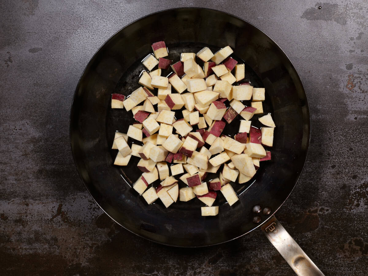 the raw potatoes in the hot oil in the pan
