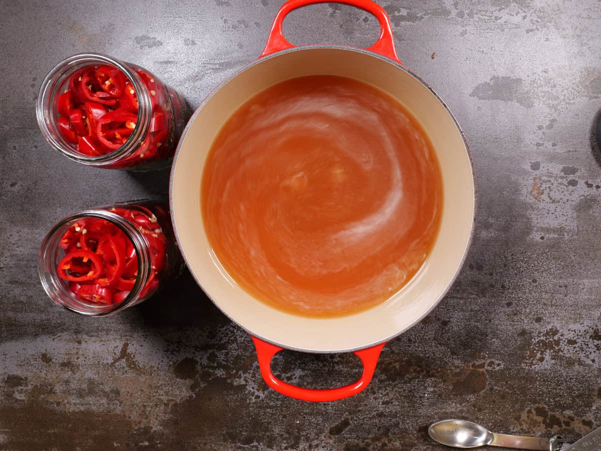 brine after mixing in the salt and sugar, jars with peppers to measure