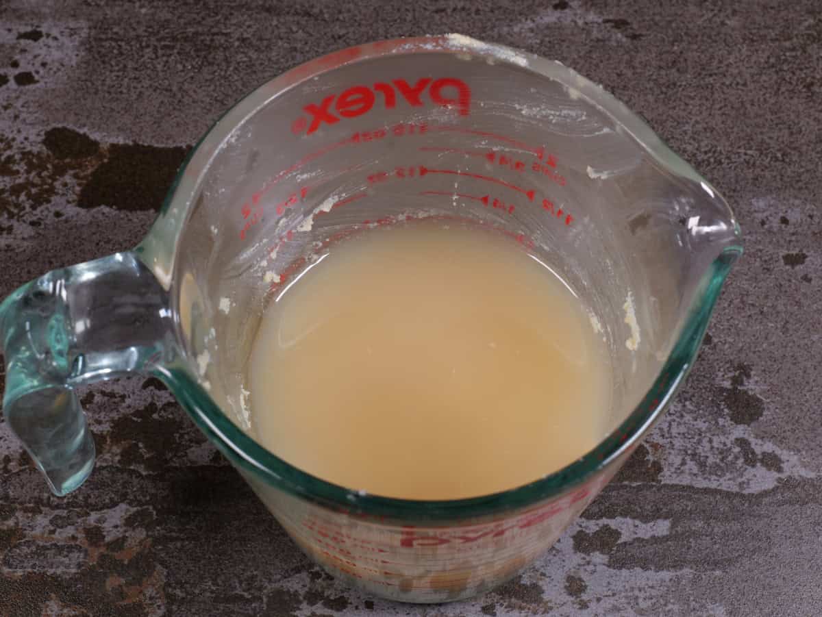 The lemon juice over the tahini in the measuring cup.