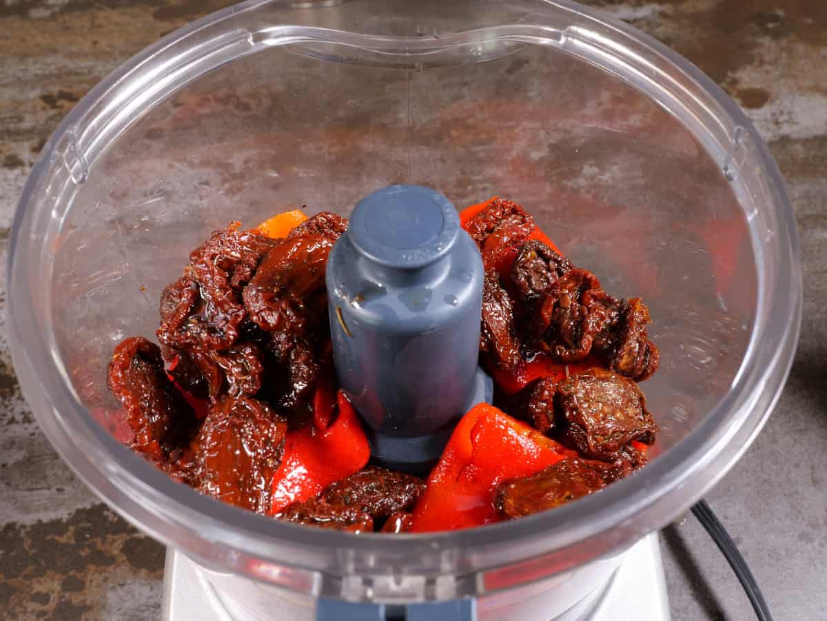 Romesco sauce, step 3, place red peppers and sundried tomatoes in the food processor.