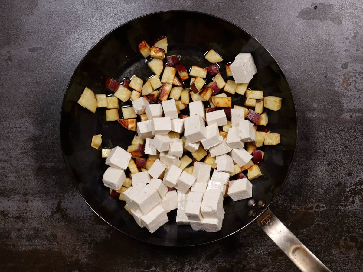 the raw tofu added to the pan of potatoes