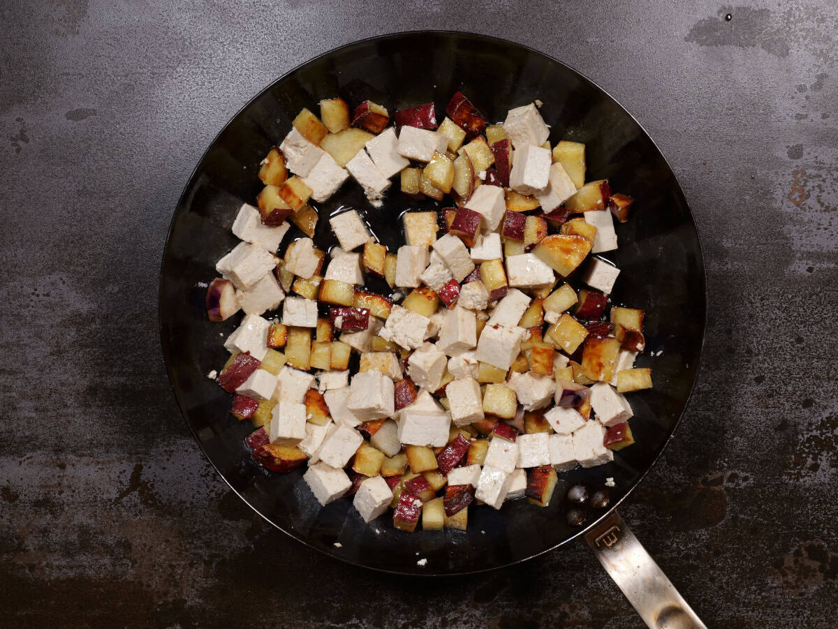 the tofu is heated up in the pan of potatoes