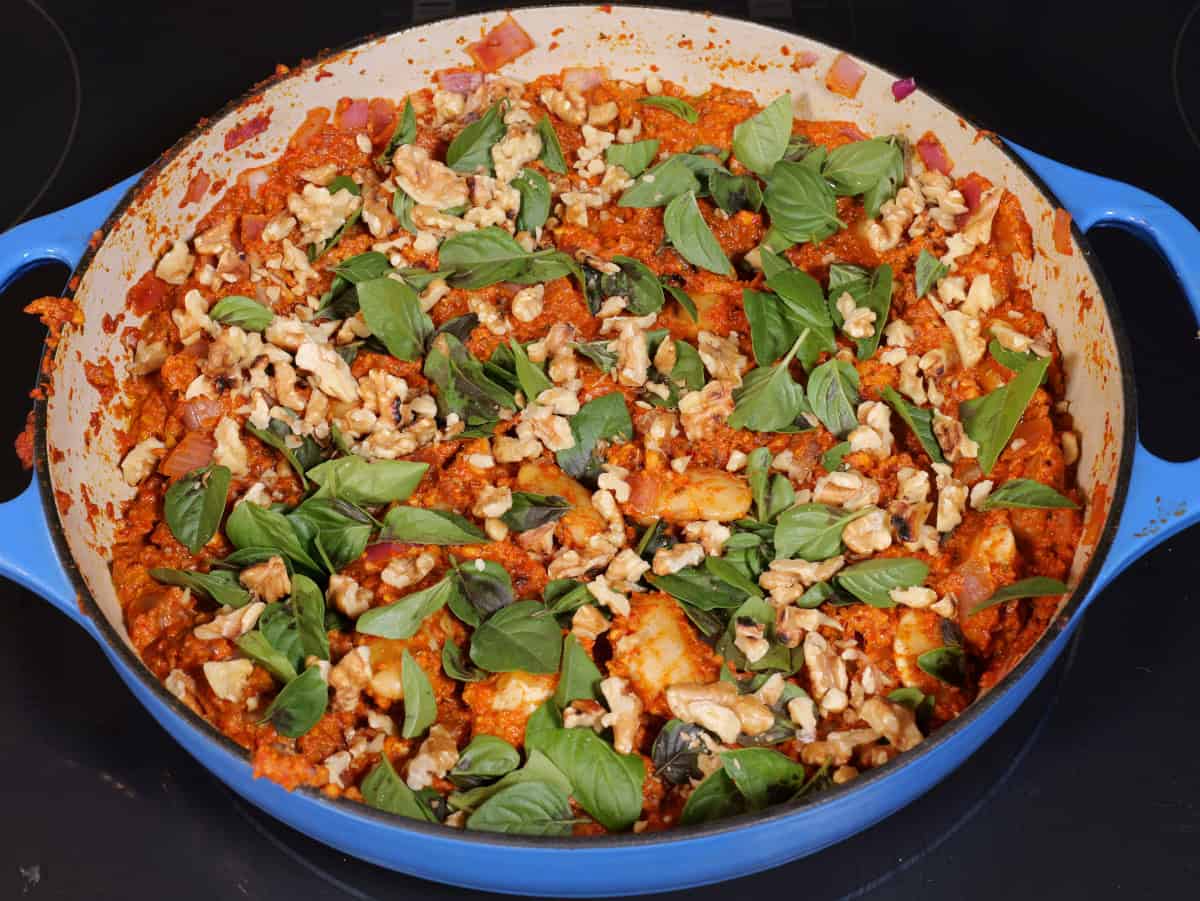 final dish with fresh basil leaves and chopped walnuts on top