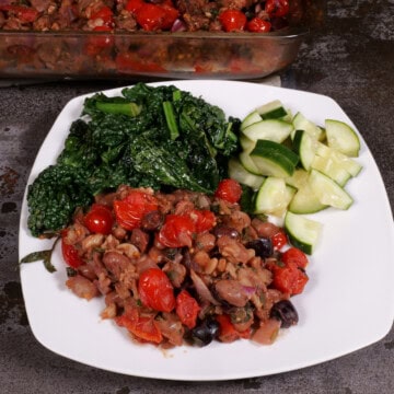 plated bean, bread, and tomato casserole with lacinato kale and cucumbers in vinegar