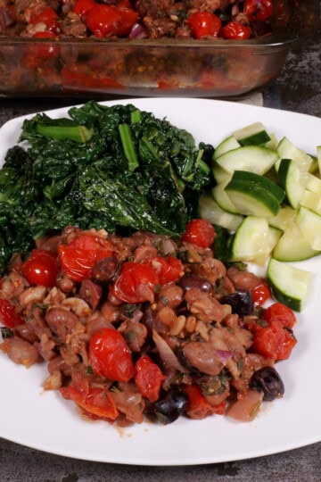 plated bean, bread, and tomato casserole with lacinato kale and cucumbers in vinegar